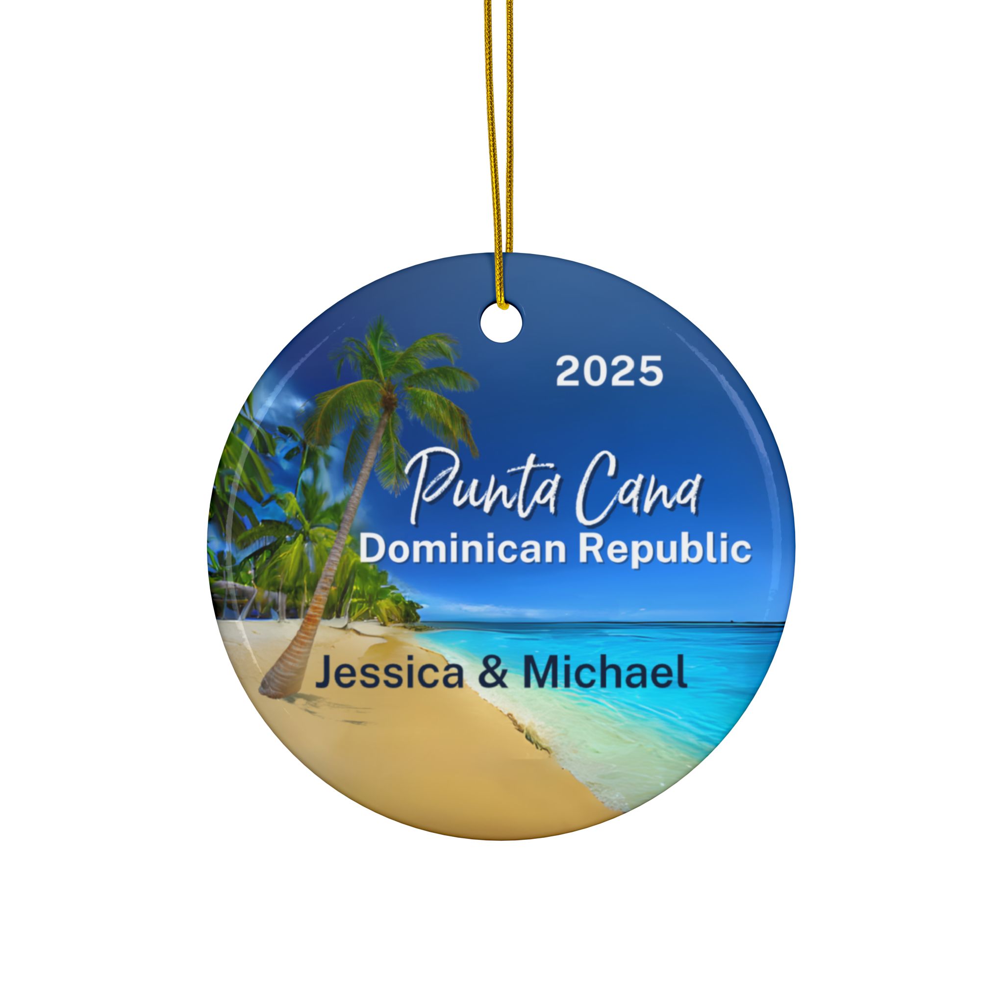 Round ornament featuring a tropical Punta Cana beach scene with palm trees, blue ocean, and sky. Text reads: 2025 Punta Cana Dominican Republic Jessica & Michael. Includes a gold string for easy hanging.